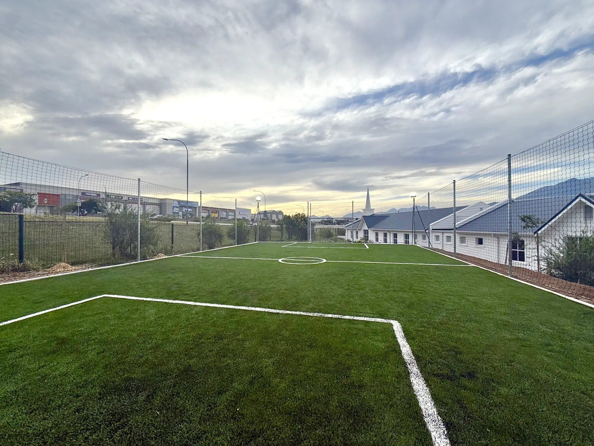 Artificial grass sports field with white markings and perimeter netting