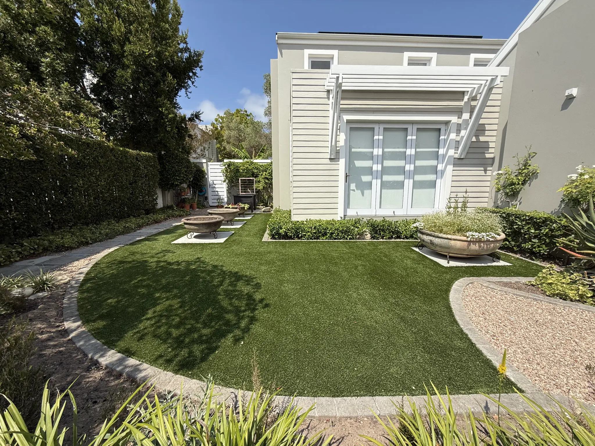Artificial grass front garden lawn in front of a light-coloured house